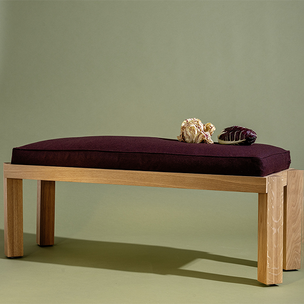 Wooden bench with a purple cushion on a plain background