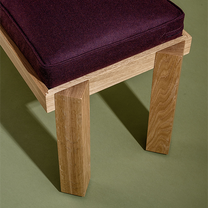 Wooden bench with a purple cushion on a green background