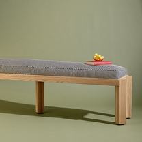 Wooden bench with striped cushion on a green background