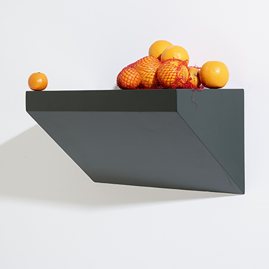 Dark gray wall-mounted shelf with decorative items on a white background