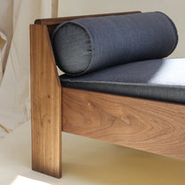 Wooden bench with blue cushion on a neutral background
