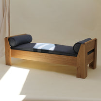 Wooden daybed with a denmin like cushion on a beige background