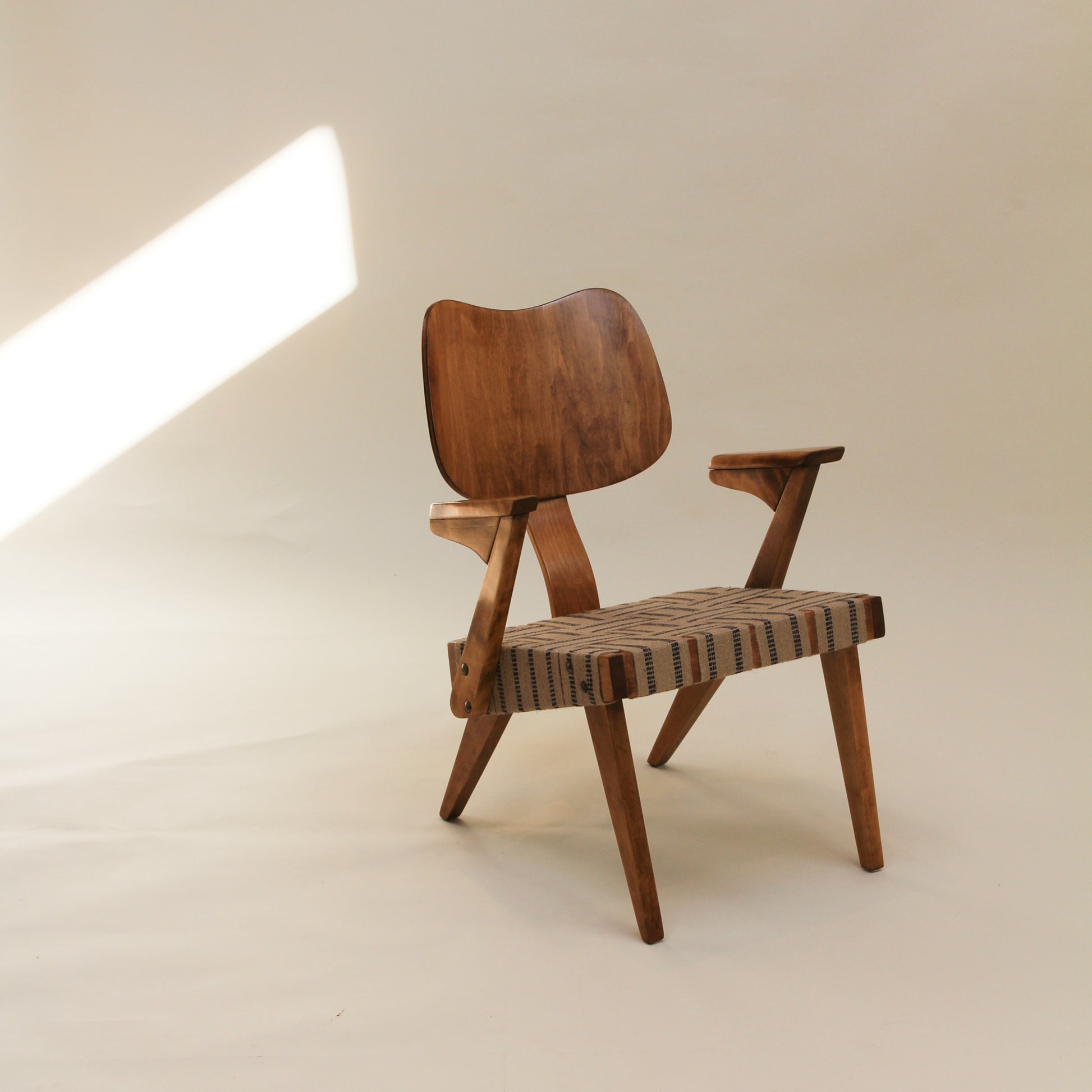 Wooden Russell Spanner chair with woven seat on a white background