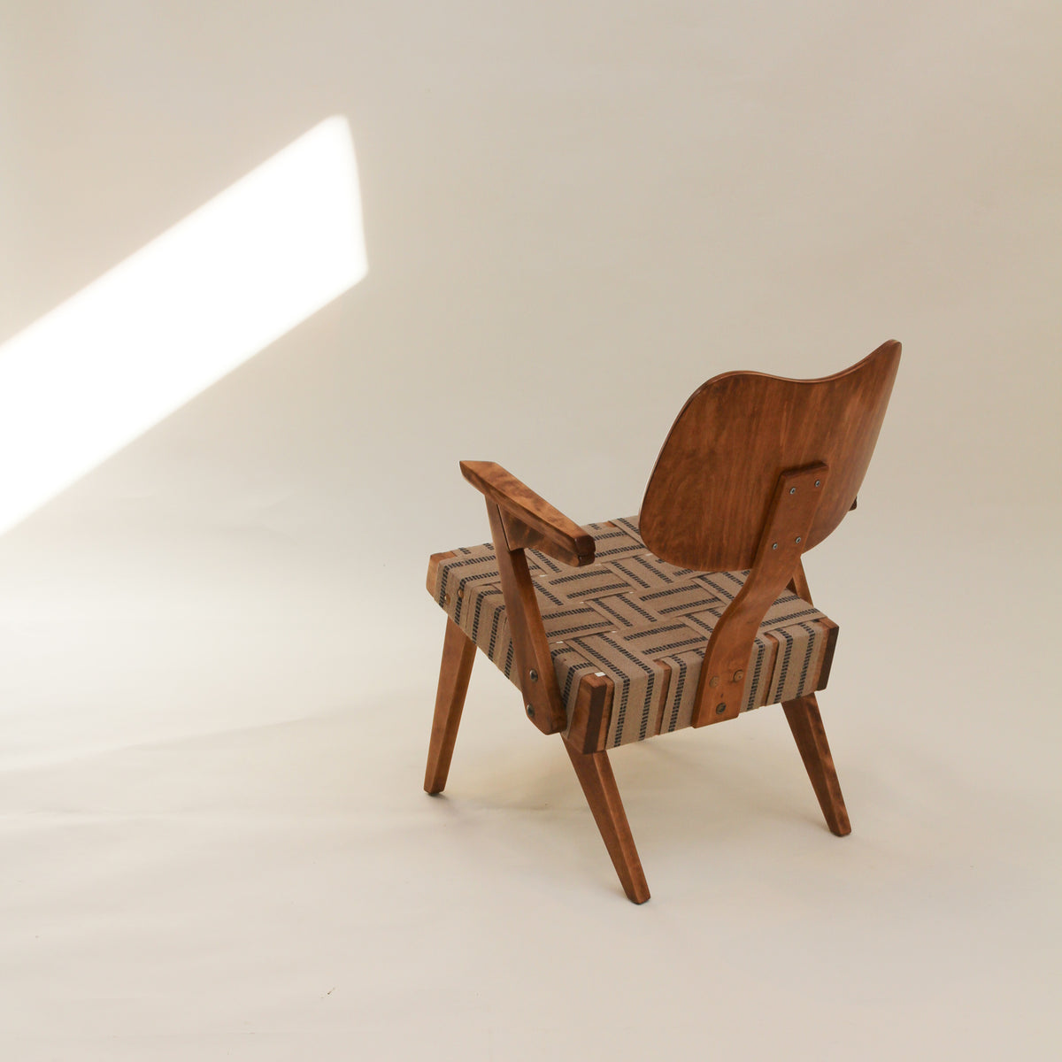 Wooden chair with a woven webbing seat on a plain background