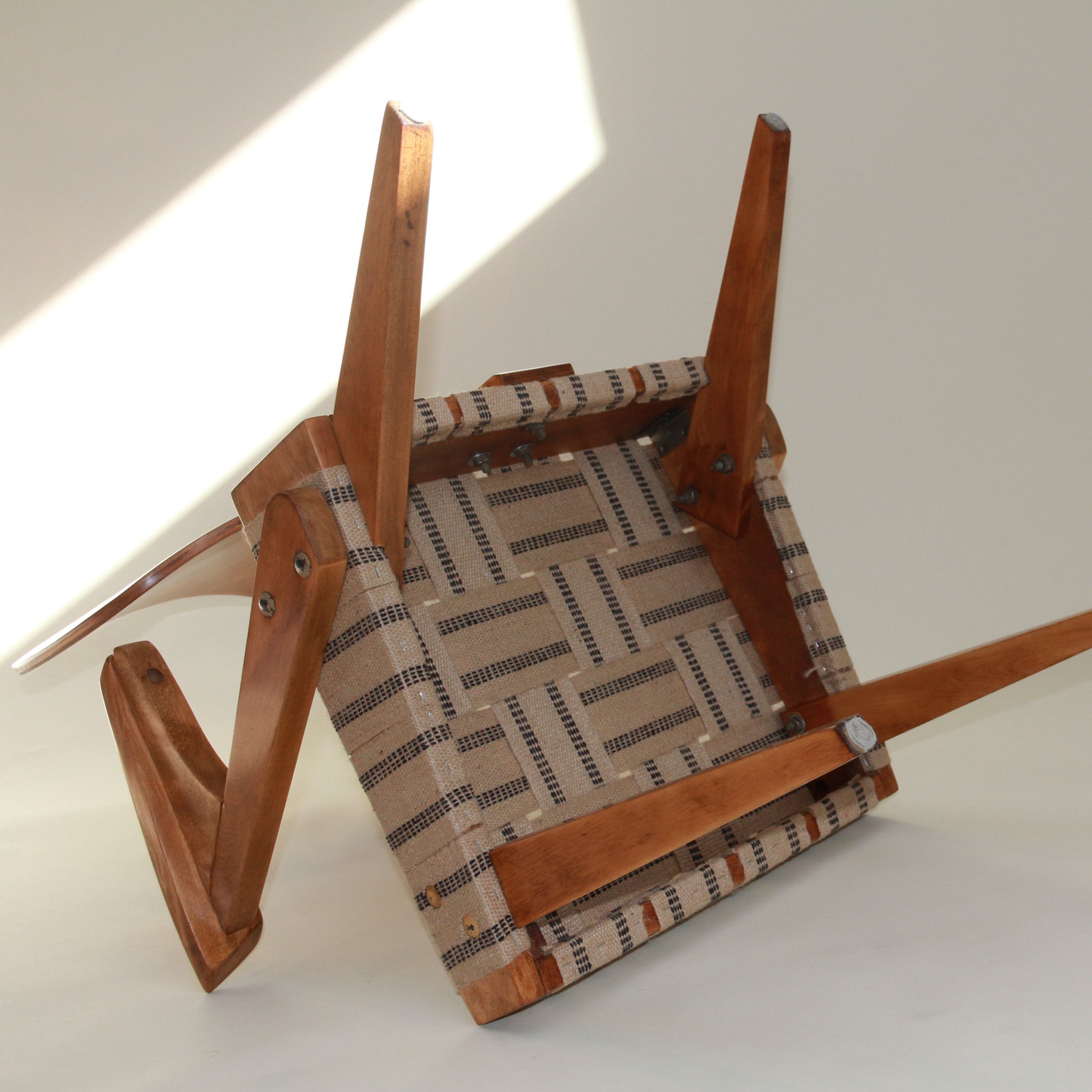 Wooden chair with patterned webbing seat on a white background