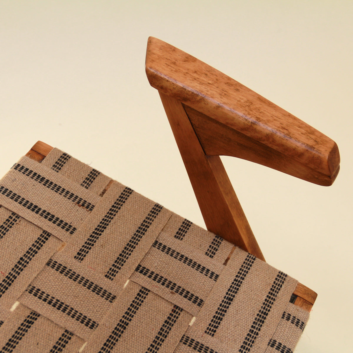 Wooden chair with woven seat on a beige background