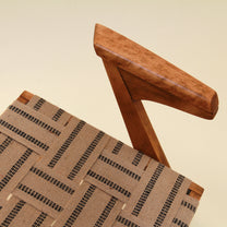 Wooden chair with woven seat on a beige background
