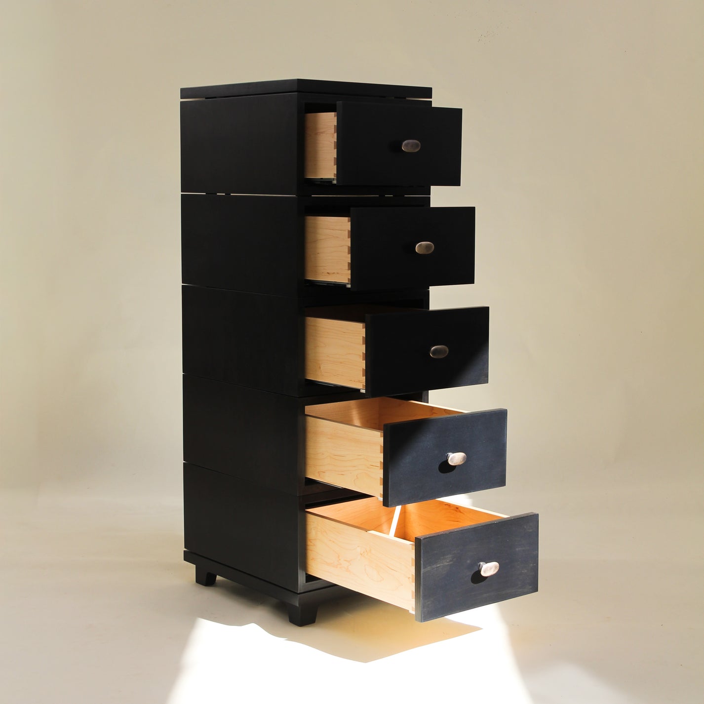 Black and wooden drawer unit on a beige background