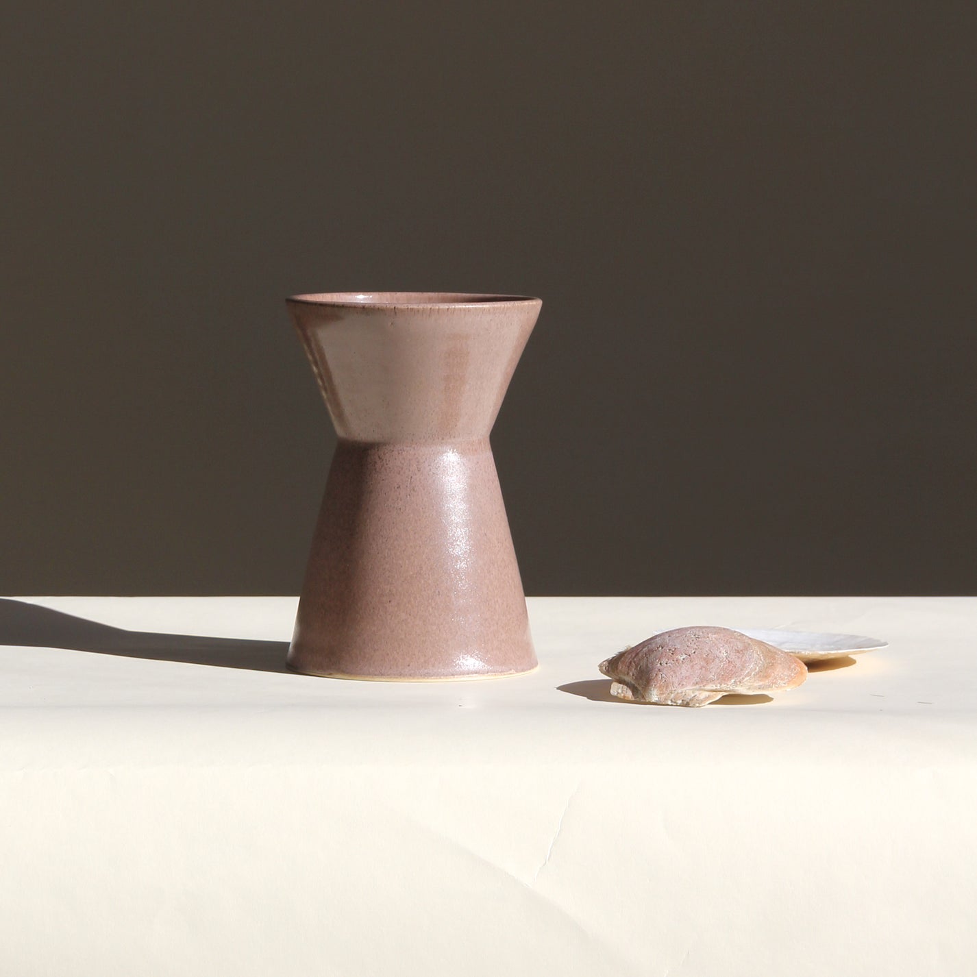 Ceramic vase on a white surface with a dark background