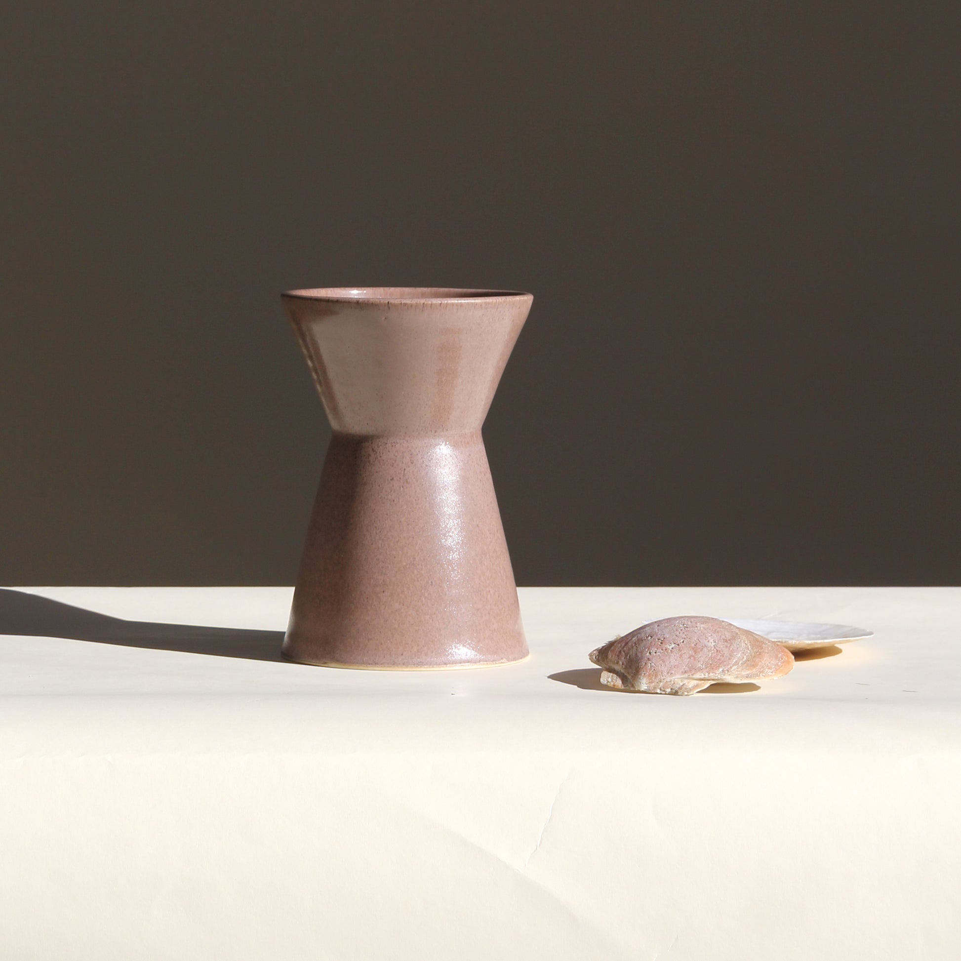 Ceramic vase on a white surface with a dark background
