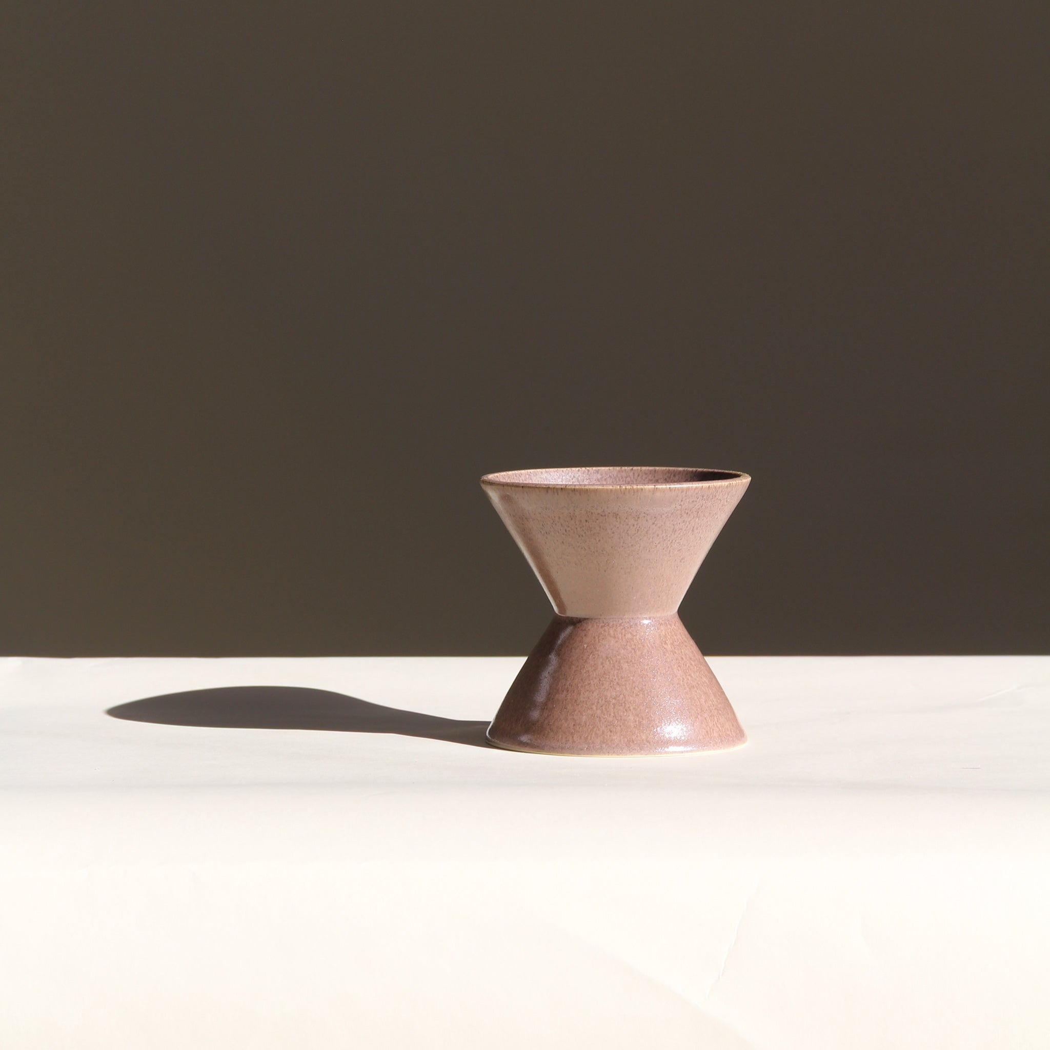 Ceramic vase with a unique design on a white surface with a dark background