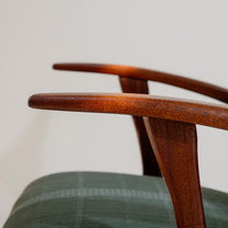 Close-up of a wooden chair's armrest with a blurred background