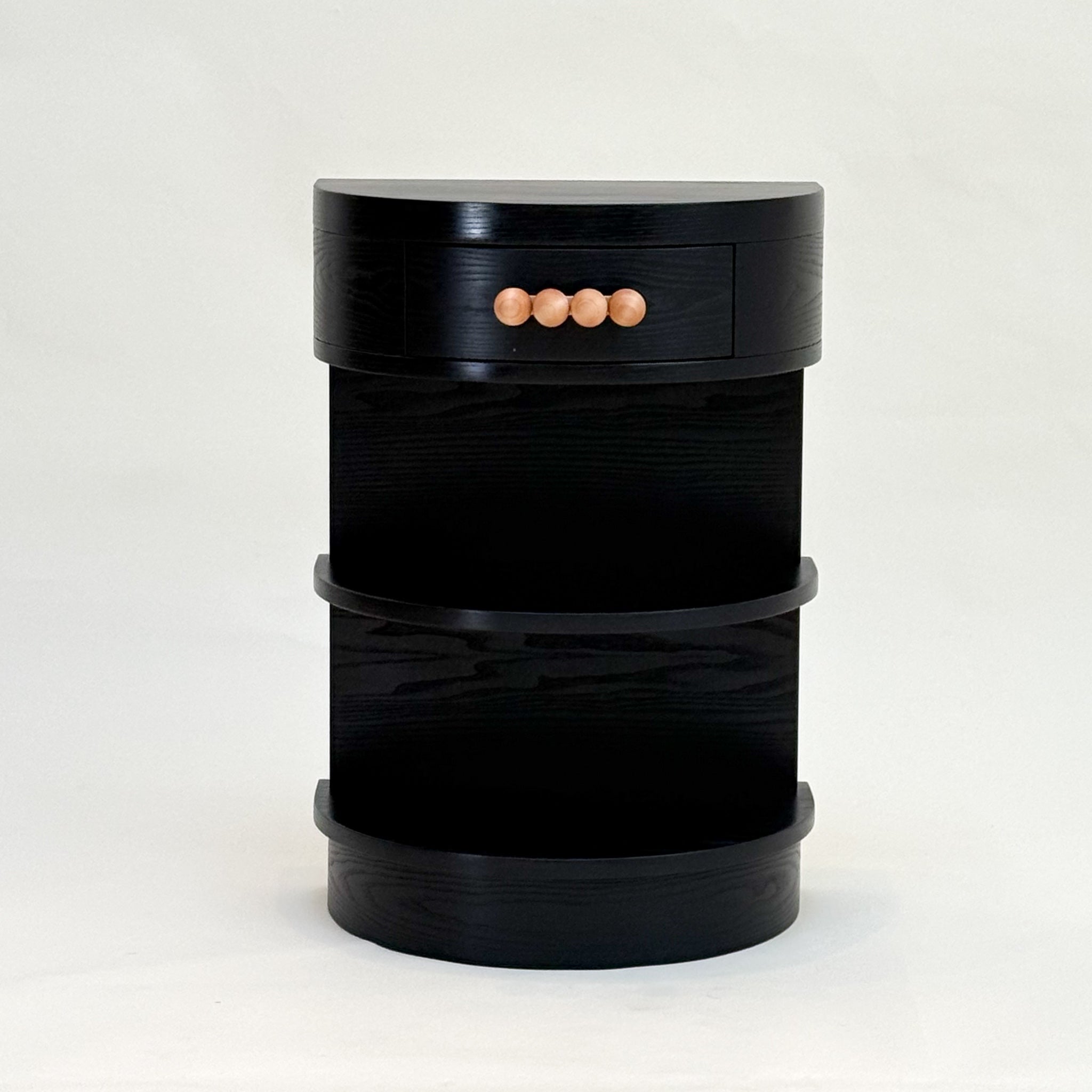 Black demi-lune nightstand with wooden knobs on a white background