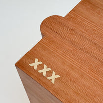 Close up of wooden table with 'XXX' engraving on a white background