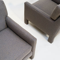 Two gray micro-checked Milo Baughman-style  upholstered chairs on a white background