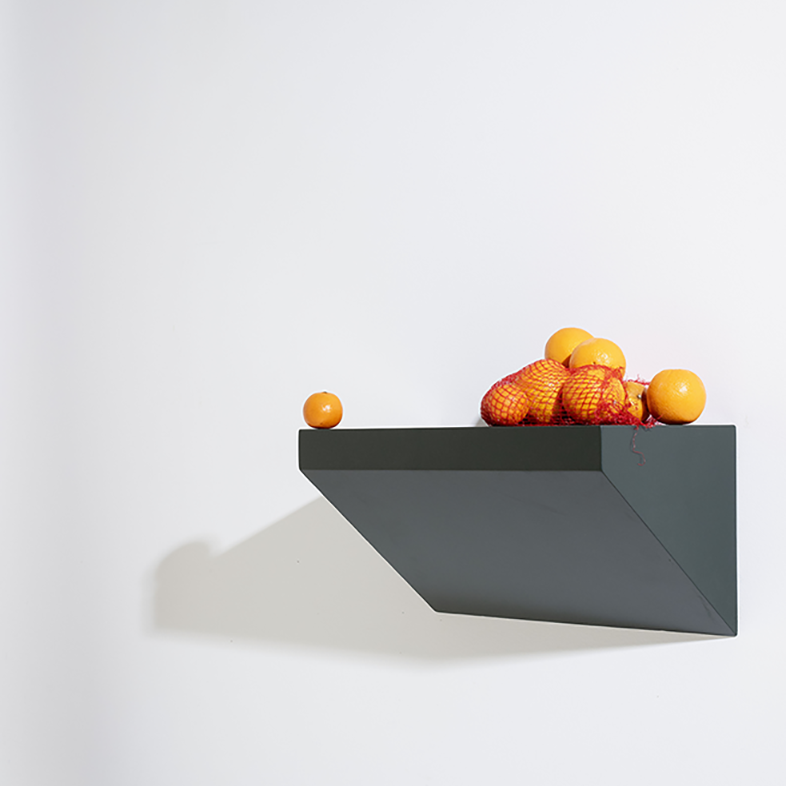 Geometric dark grey wall shelf with fruits on a white background