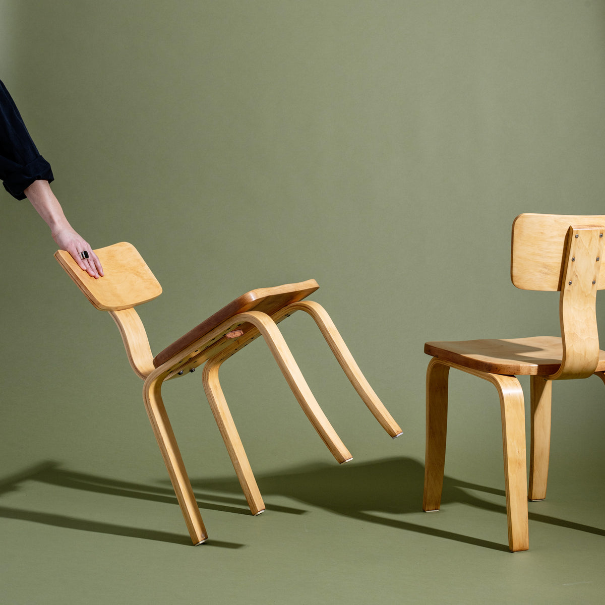 Wooden chair being adjusted against a green background