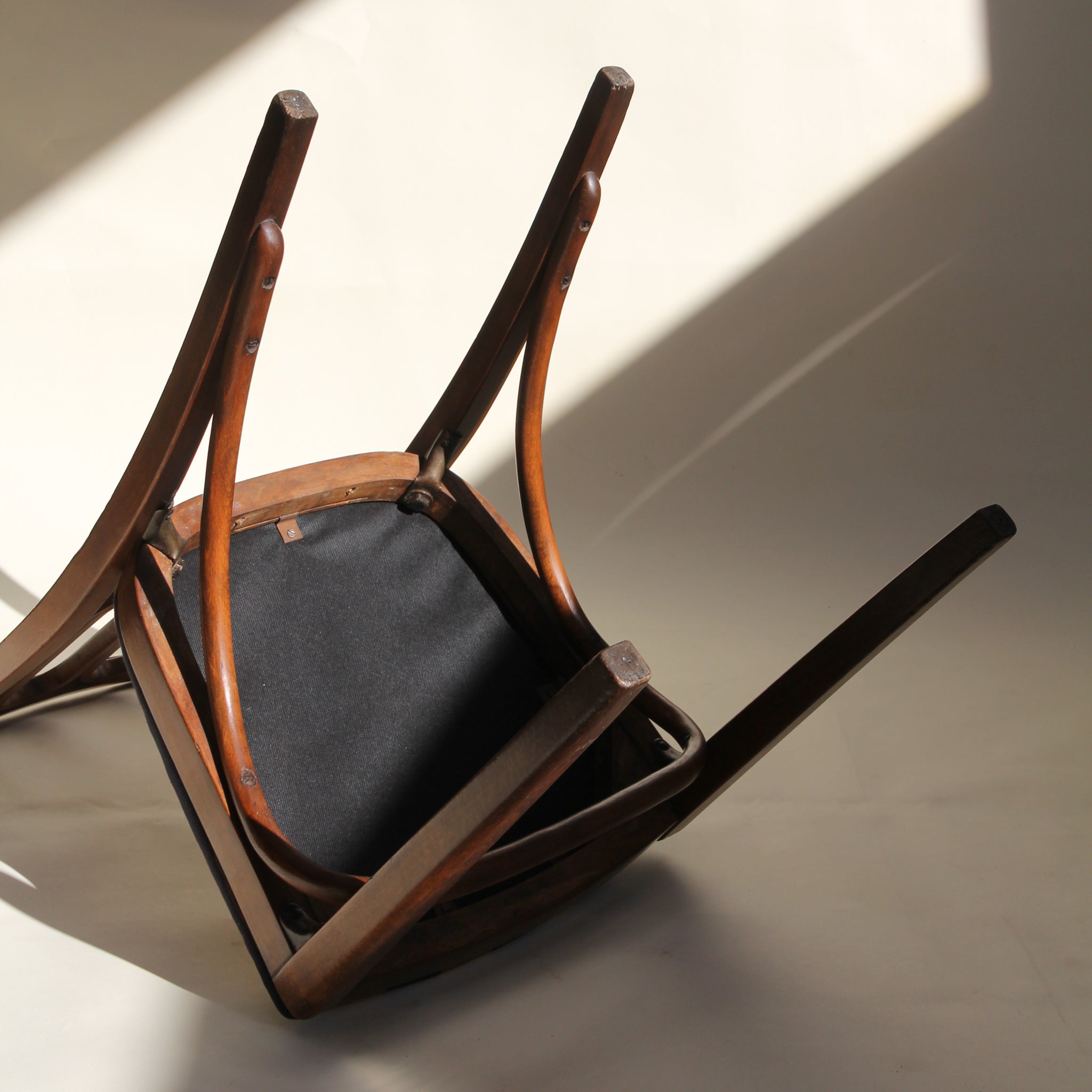 Underside of wooden chair on a light background