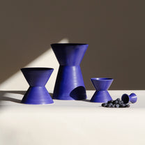 Set of blue ceramic vessels on a neutral background